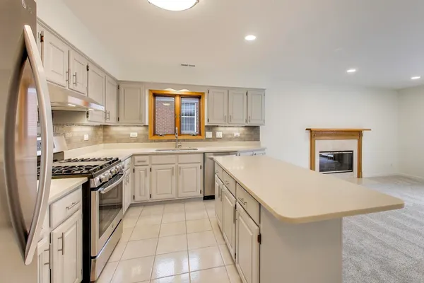 a kitchen with a sink stove top oven and refrigerator