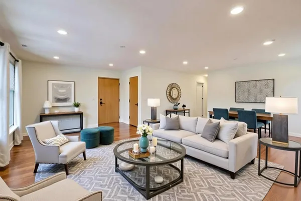 a living room with furniture a rug and a lamp