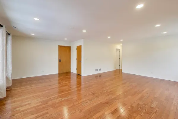 a view of an empty room with wooden floor