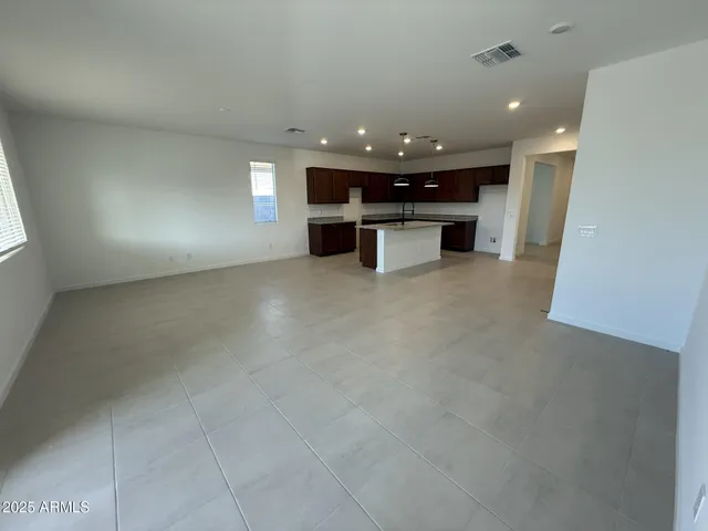 an open space with kitchen view and a refrigerator