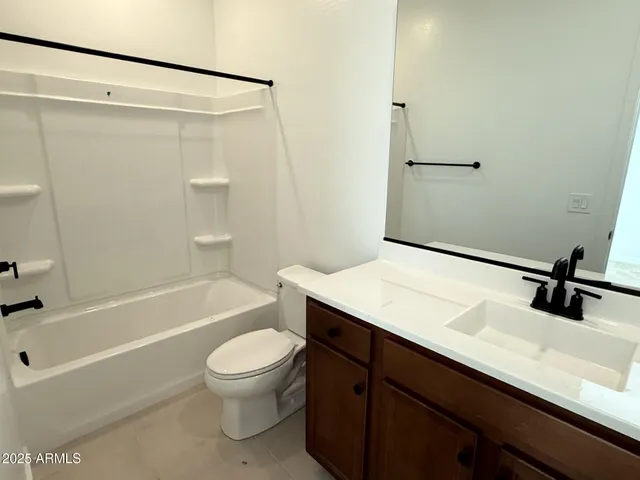 a bathroom with a granite countertop sink toilet a mirror and shower
