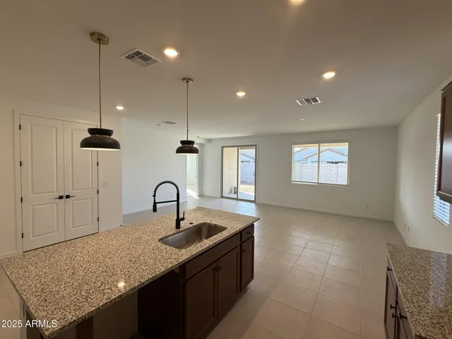 a kitchen with granite countertop a sink a counter top space and cabinets