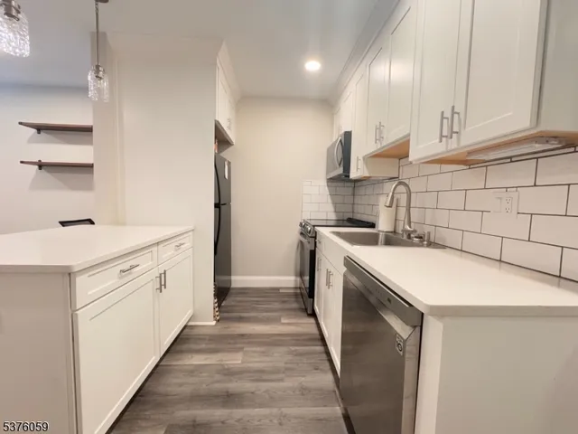 a kitchen with a sink a stove a refrigerator and chairs
