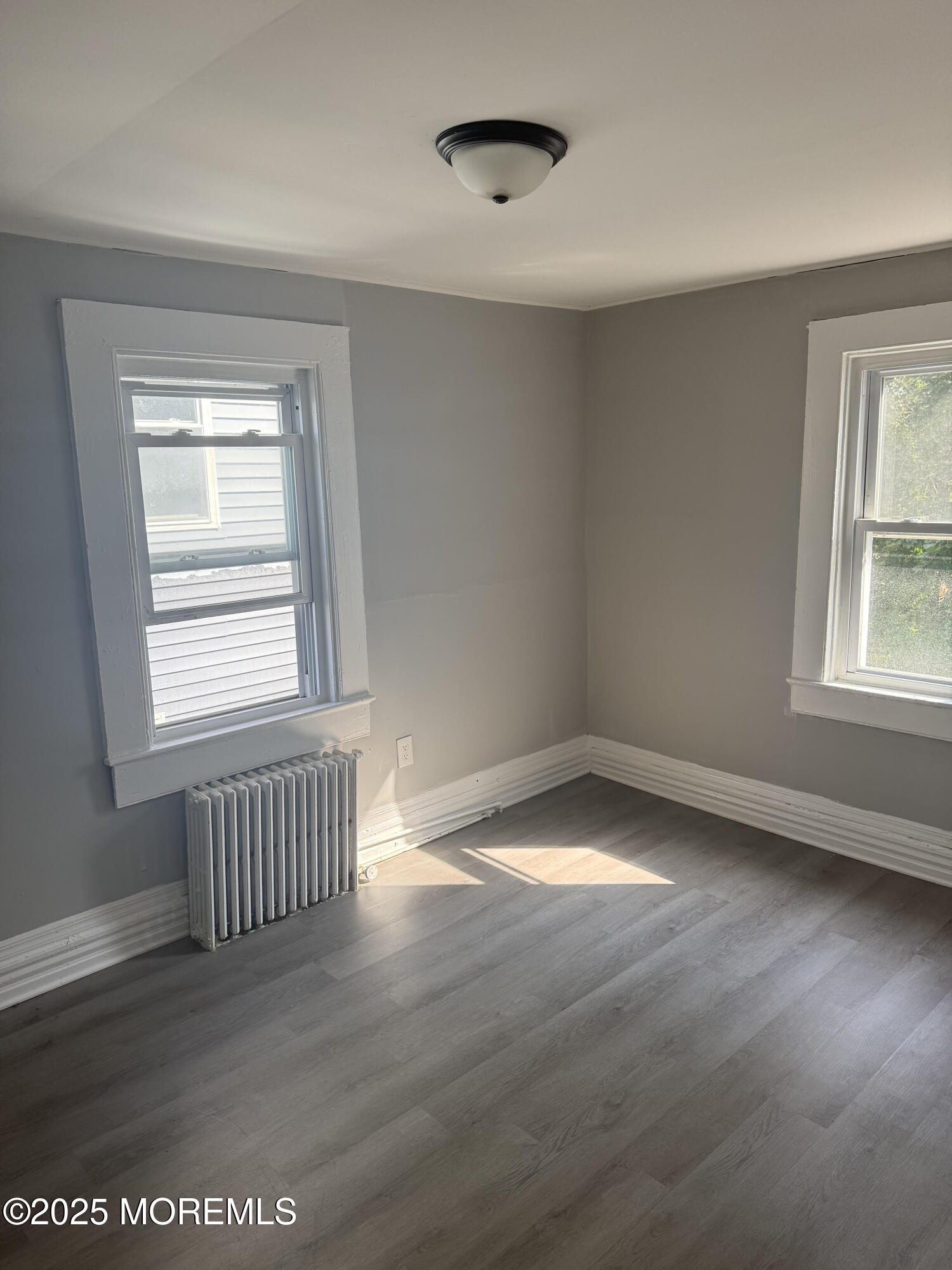 79 4th Avenue, Unit 1 Long Branch, NJ 07740 - Photo 6 of 11 a view of an empty room with wooden floor and a window