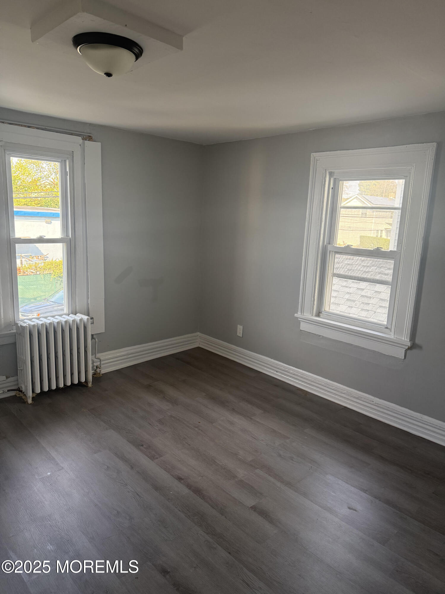 79 4th Avenue, Unit 1 Long Branch, NJ 07740 - Photo 7 of 11 an empty room with wooden floor and windows