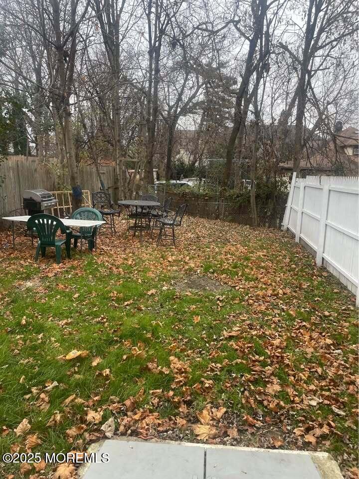 79 4th Avenue, Unit 1 Long Branch, NJ 07740 - Photo 10 of 11 a view of backyard with table and chairs and wooden fence