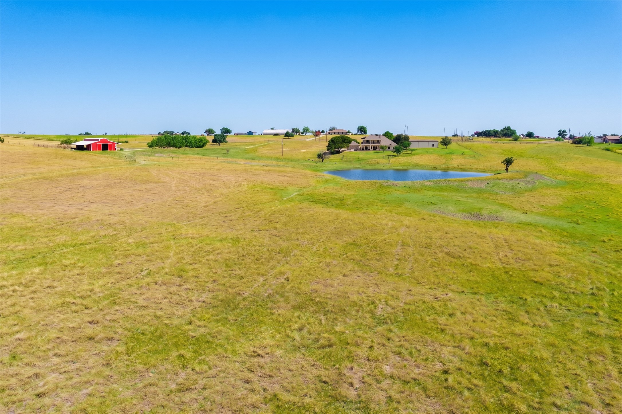 20145 Janak Road Coupland, TX 78615 - Photo 36 of 40 Rolling hills and a placid pond enhance this expansive rural property, offering serene country living.