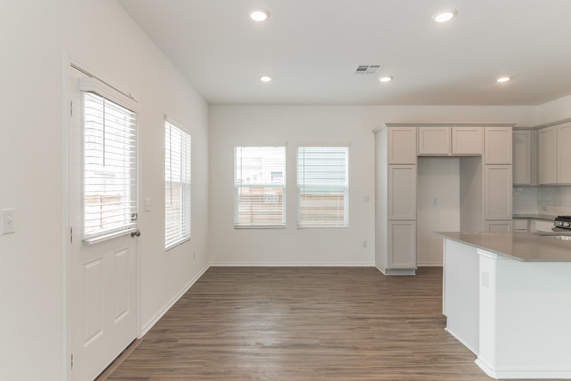 231 Rioja Kyle, TX 78640 - Photo 7 of 29 Kitchen featuring dark wood-type flooring, recessed lighting, light stone countertops, backsplash, and gray cabinetry