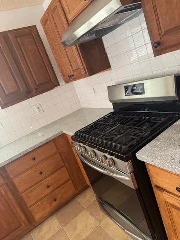 a kitchen with granite countertop a sink stove and cabinets