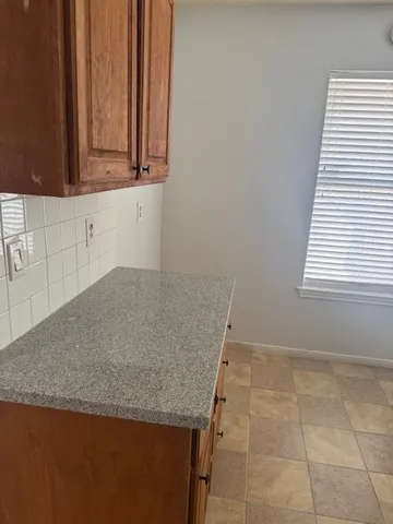 a view of an empty room with a fireplace and a window