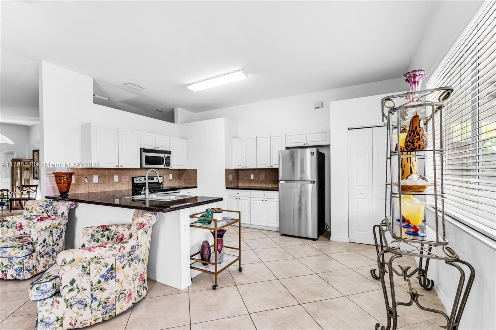 2819 Augusta Lane Homestead, FL 33035 - Photo 11 of 24 a kitchen with stainless steel appliances kitchen island granite countertop a refrigerator and a stove top oven