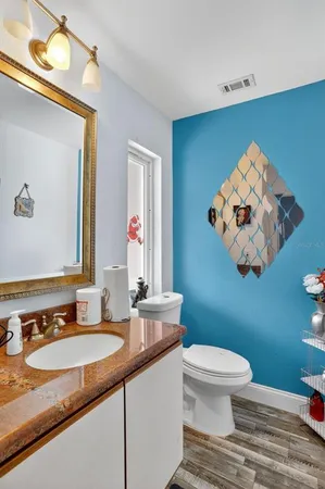 a bathroom with a granite countertop sink mirror and toilet