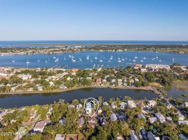 a view of a house with a small yard and large trees