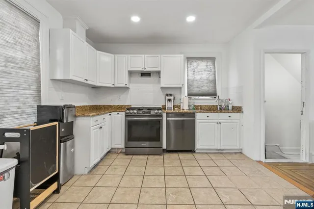 a kitchen with a stove sink and cabinets