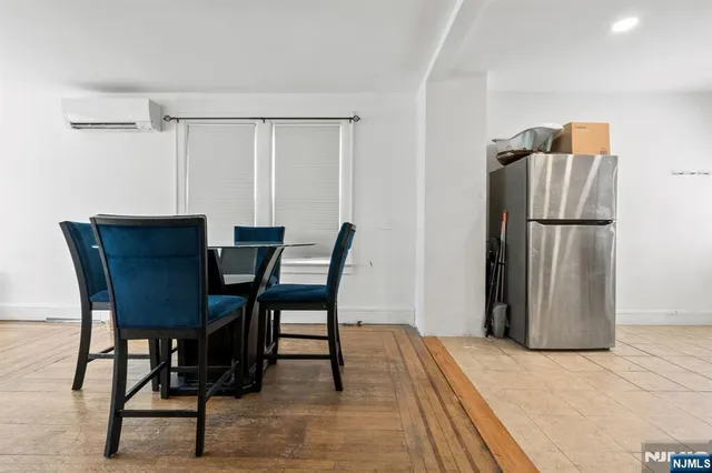 a dining room with furniture and a refrigerator