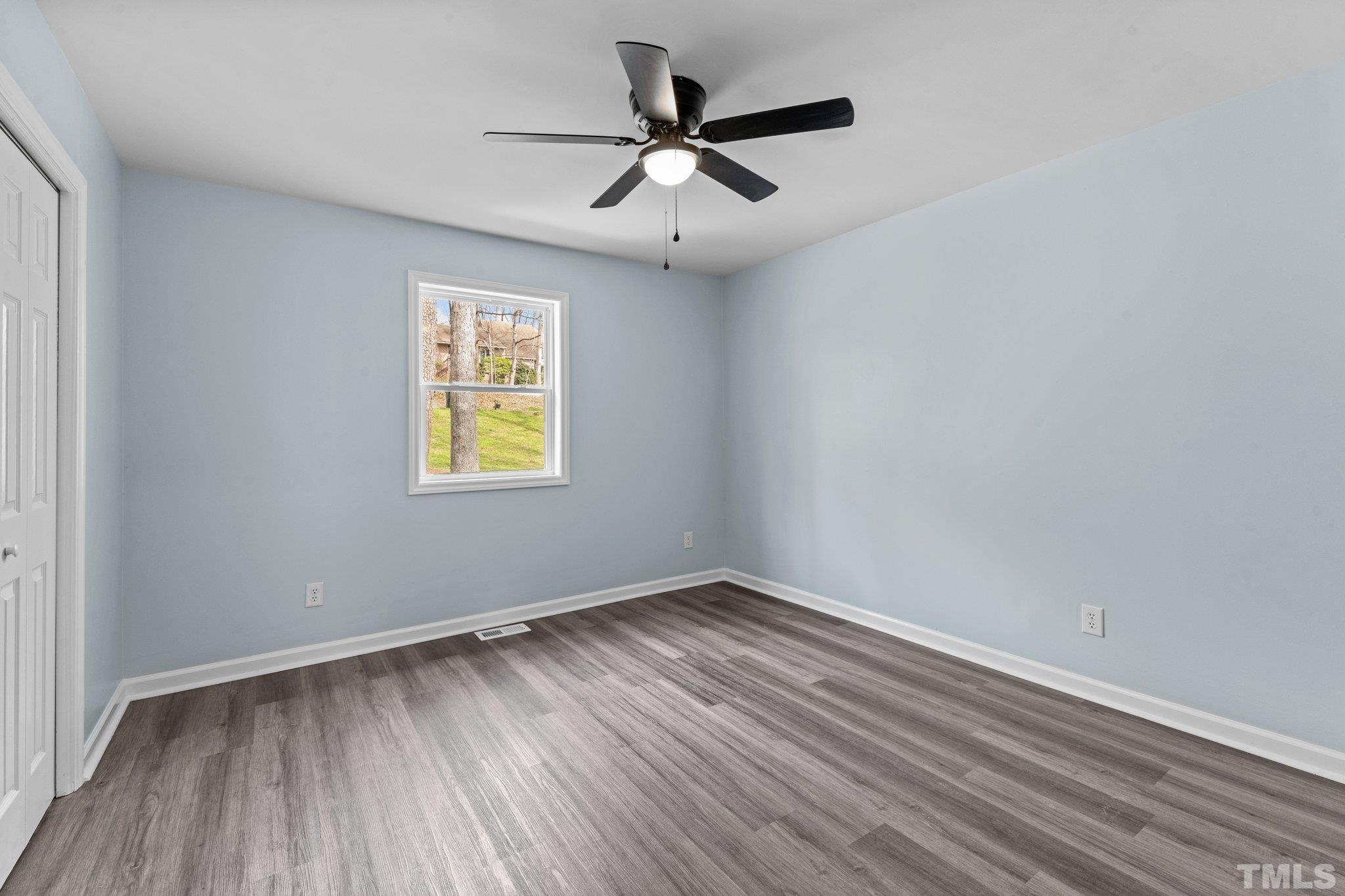 4006 Arckelton Drive, Unit 4006 & 4004 Raleigh, NC 27612 - Photo 20 of 34 an empty room with wooden floor ceiling fan and windows