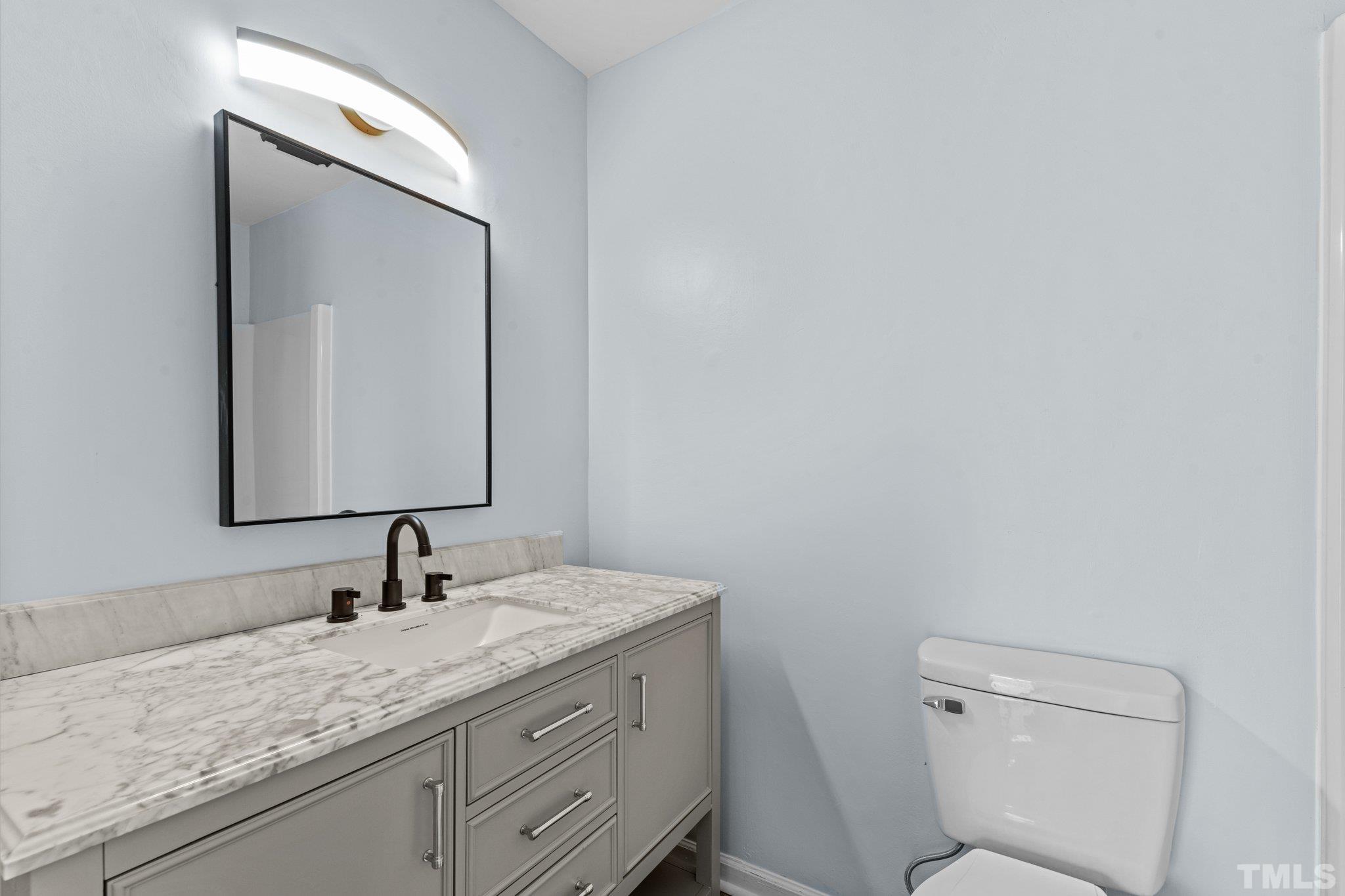 4006 Arckelton Drive, Unit 4006 & 4004 Raleigh, NC 27612 - Photo 23 of 34 a bathroom with a granite countertop toilet a sink and mirror
