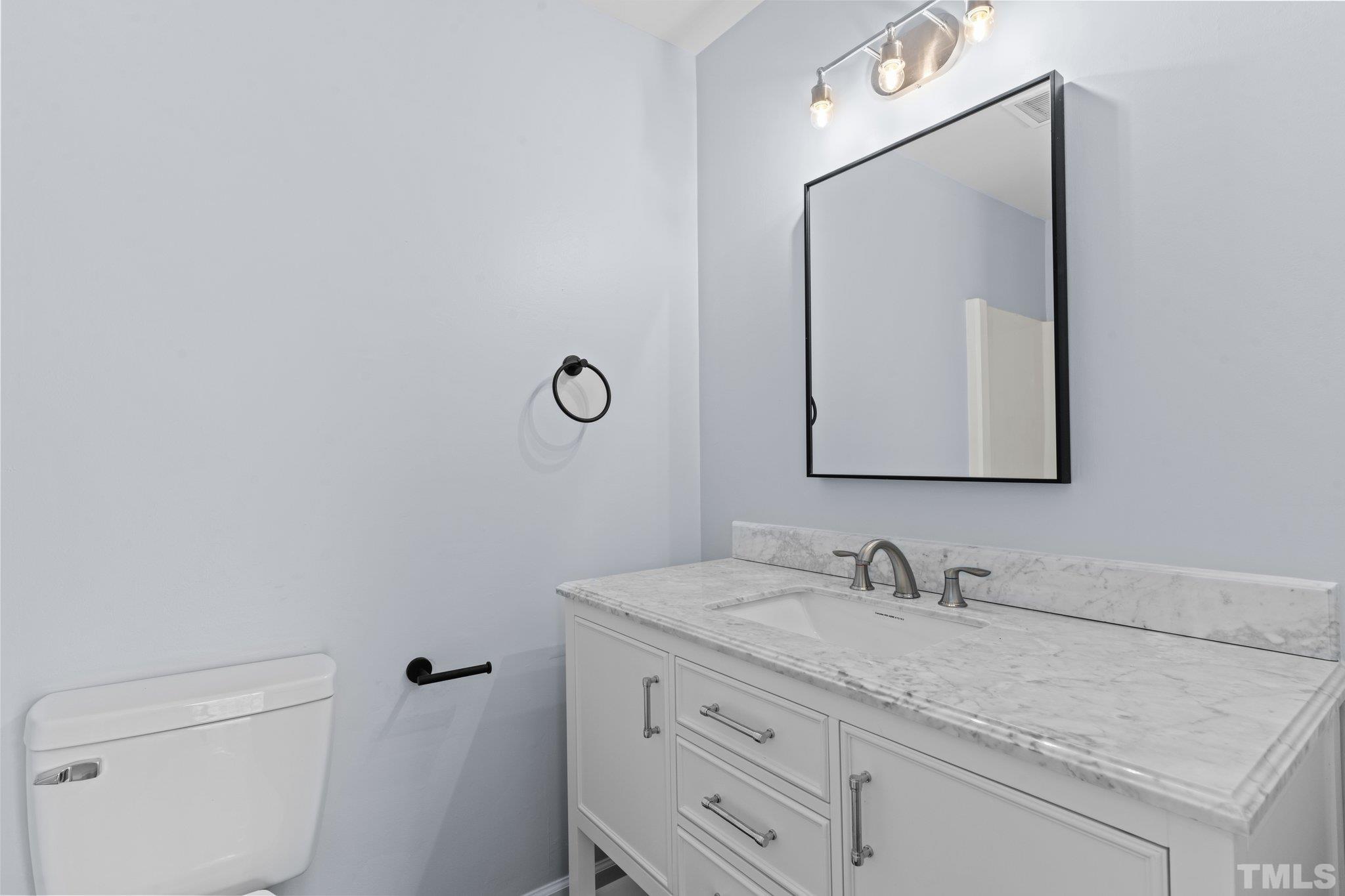 4006 Arckelton Drive, Unit 4006 & 4004 Raleigh, NC 27612 - Photo 34 of 34 a bathroom with a granite countertop sink vanity and mirror