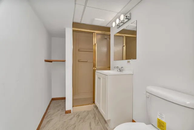 a bathroom with a sink a toilet a mirror and shower