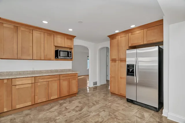 a kitchen with stainless steel appliances granite countertop a refrigerator and a sink