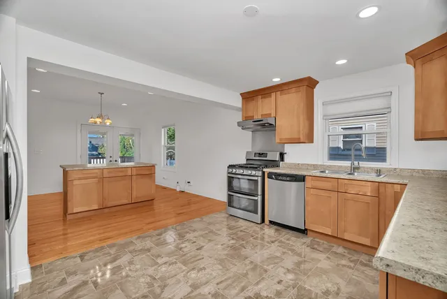 a large kitchen with stainless steel appliances granite countertop a sink and cabinets
