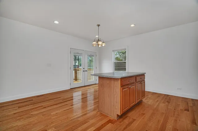 a kitchen with wooden floors and white cabinets