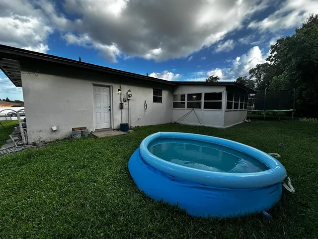 a front view of house with garden and trees