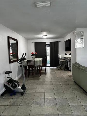 a living room with furniture a flat screen tv and kitchen view