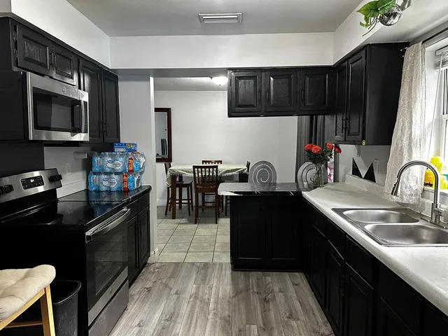 a kitchen with a sink stove top oven and cabinets