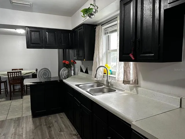 a kitchen with granite countertop a sink dishwasher a stove a refrigerator and cabinets with wooden floor