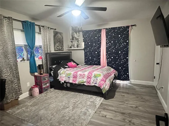 a bedroom with a bed dresser and flat screen tv
