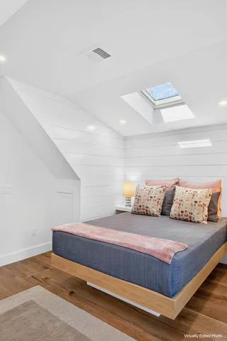 a living room with a bed and a night stand