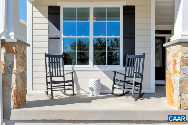 an empty room with wooden floor mirror and windows