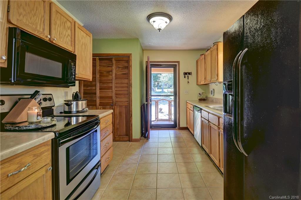 263 Laurel Branch Road Maggie Valley, NC 28751 - Photo 11 of 32 a kitchen with stainless steel appliances granite countertop a stove top oven microwave and refrigerator