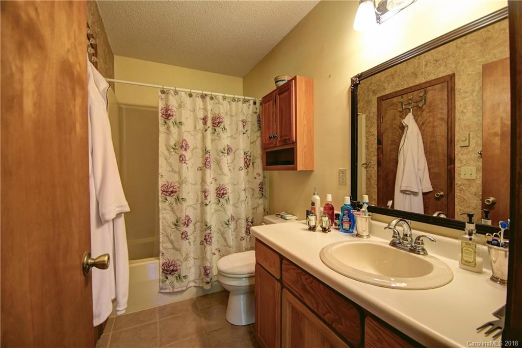 263 Laurel Branch Road Maggie Valley, NC 28751 - Photo 16 of 32 a bathroom with double vanity sink a mirror a toilet and a shower