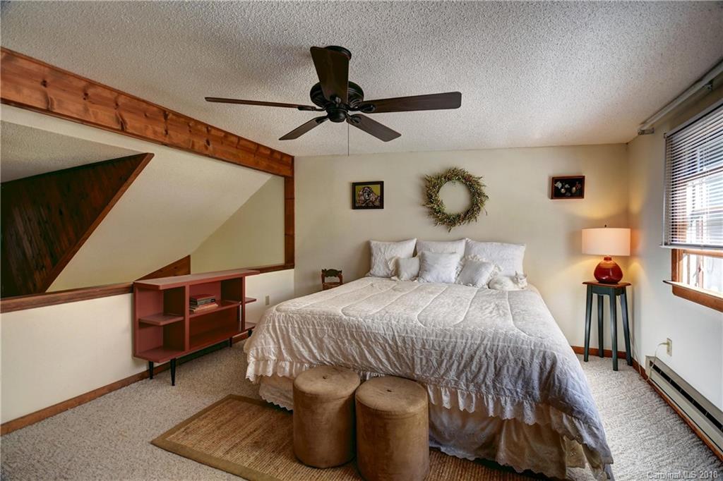 263 Laurel Branch Road Maggie Valley, NC 28751 - Photo 21 of 32 a bedroom with a bed and dresser with wooden floor