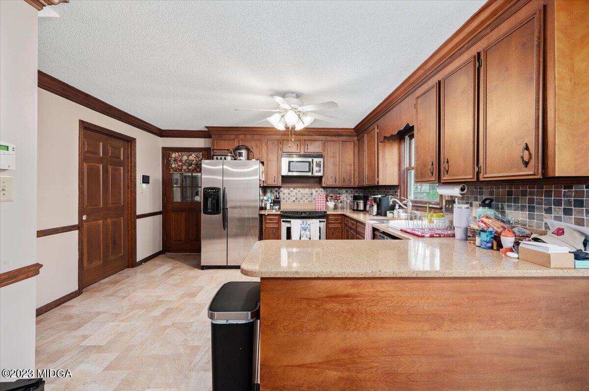 347 Castlegate Road Macon, GA 31210 - Photo 15 of 34 a kitchen with stainless steel appliances wooden cabinets a refrigerator and a stove