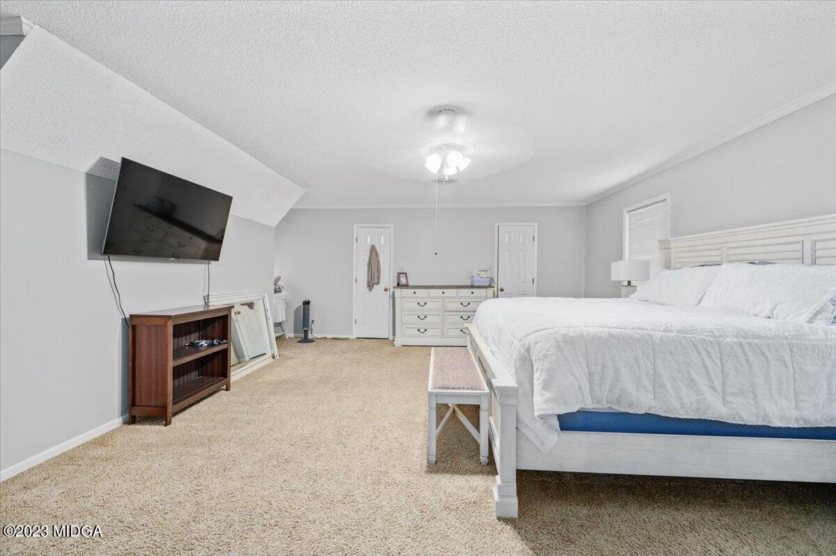 347 Castlegate Road Macon, GA 31210 - Photo 18 of 34 a spacious bedroom with a bed and a flat screen tv