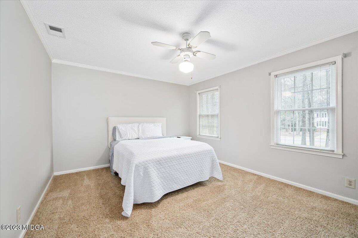 347 Castlegate Road Macon, GA 31210 - Photo 25 of 34 a spacious bedroom with a bed and a chandelier