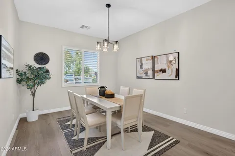 a dining room with furniture a chandelier and wooden floor