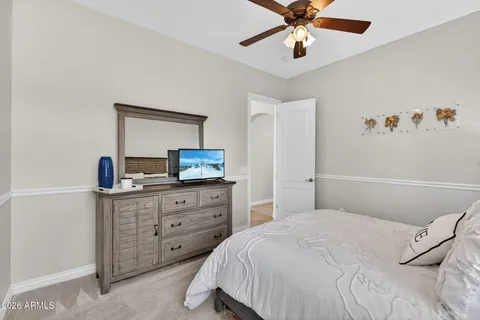 a bedroom with a bed and a flat tv screen on dresser