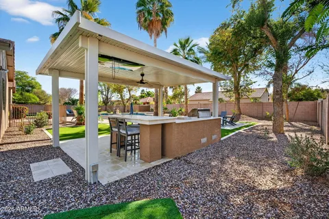 a view of a patio with table and chairs potted plants and a large tree