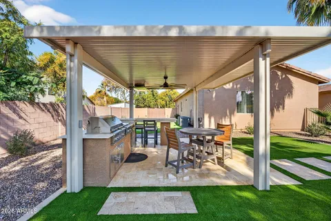 a view of a patio with table and chairs potted plants and a large tree