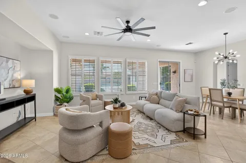 a living room with furniture kitchen view and a chandelier