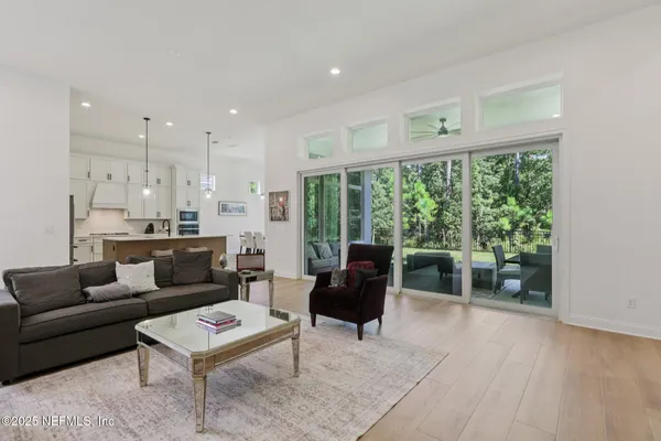 a kitchen with stainless steel appliances kitchen island a white table chairs and a refrigerator