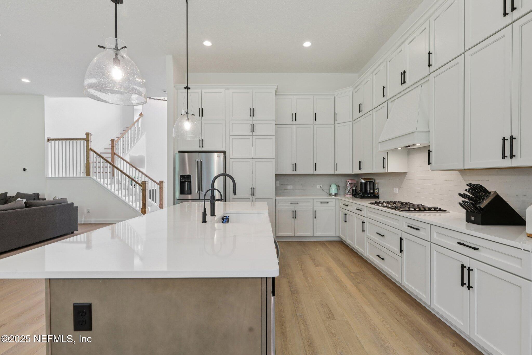 3089 Spiro Circle Jacksonville, FL 32246 - Photo 27 of 83 a kitchen with kitchen island a sink a stove a refrigerator and white cabinets