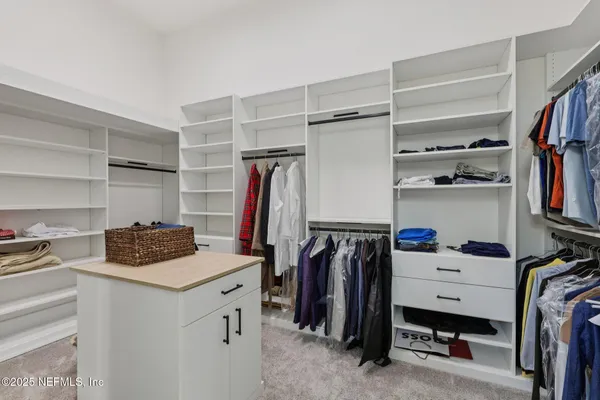 a view of a white house with a yard and potted plants