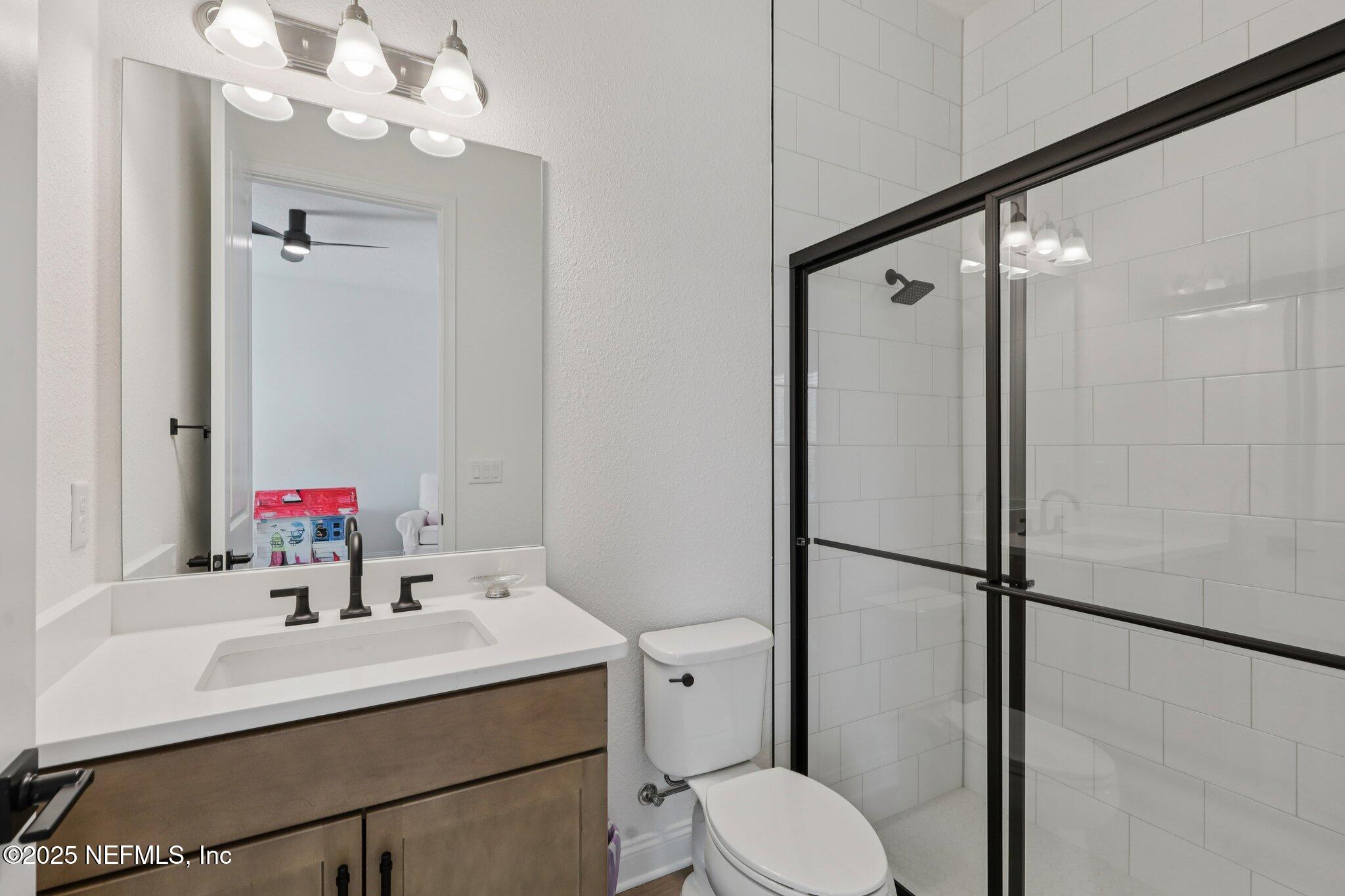 3089 Spiro Circle Jacksonville, FL 32246 - Photo 46 of 83 a bathroom with a sink vanity mirror and toilet