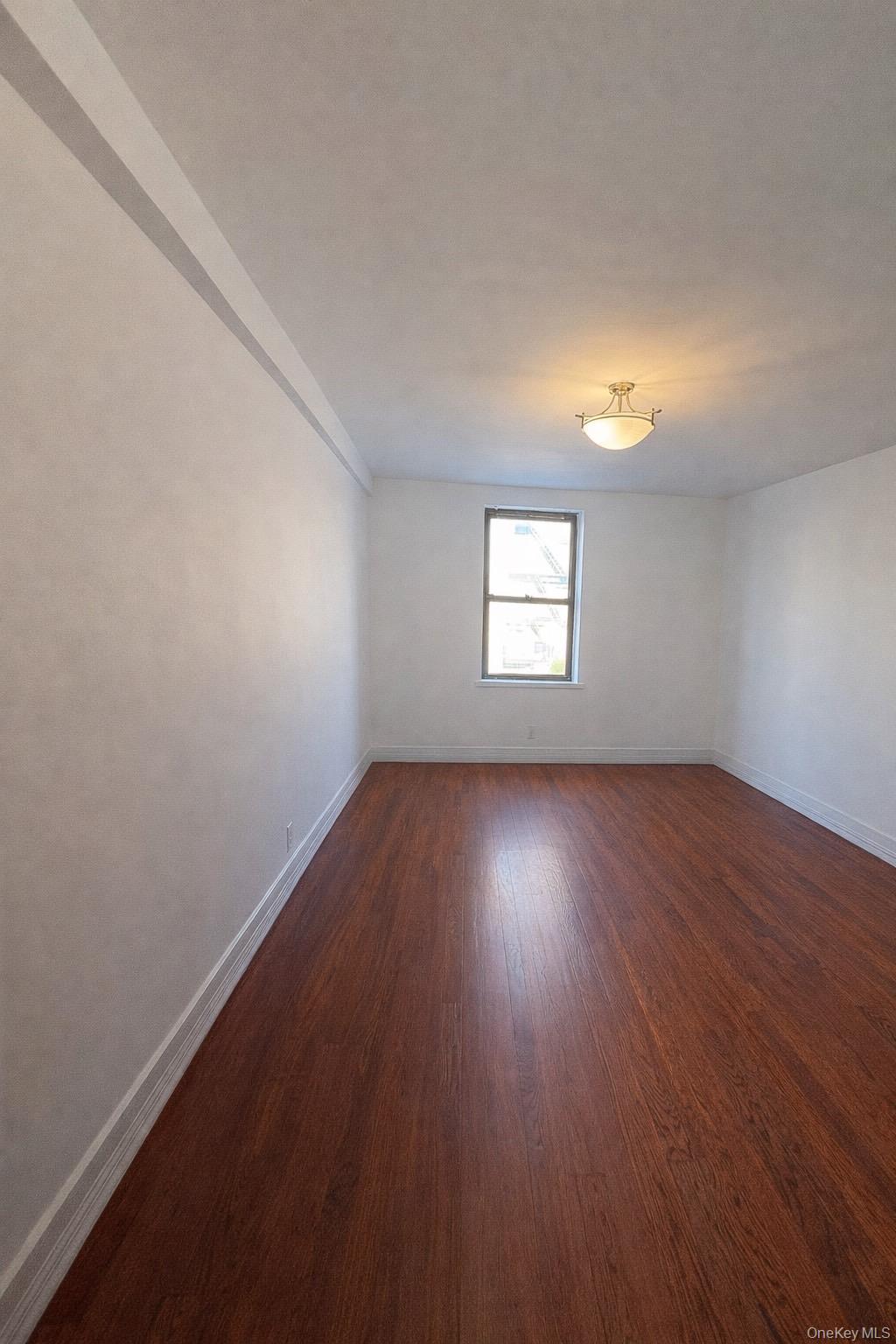 745 East 231st Street, Unit 6A Bronx, NY 10466 - Photo 3 of 7 an empty room with wooden floor and windows