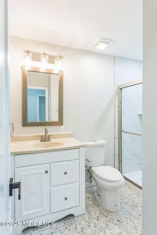 a bathroom with a toilet a sink and mirror